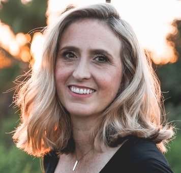 Portrait souriant d'une femme blonde au coucher du soleil