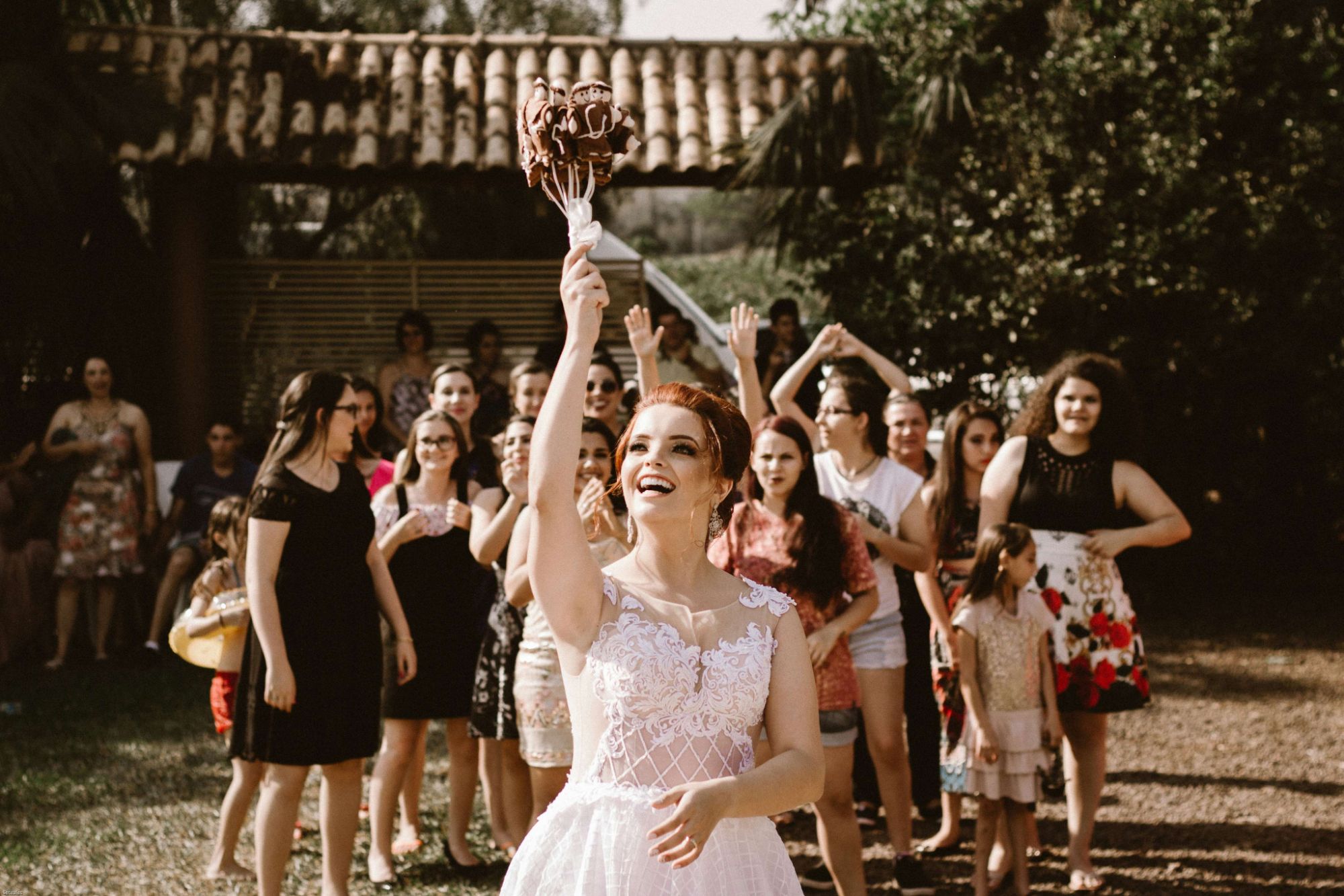 La mariée lance son bouquet devant les invitées