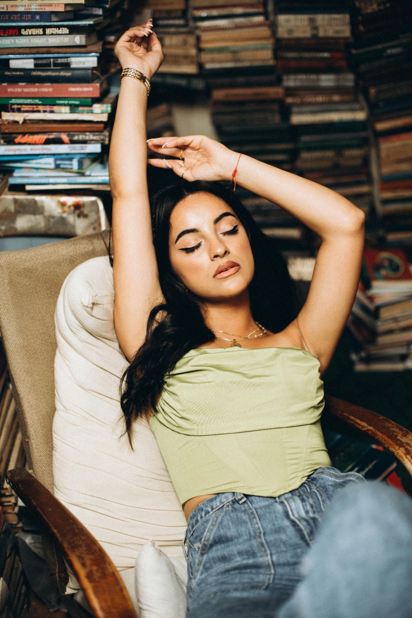 Portrait d'une femme dans un fauteuil entourée de livres